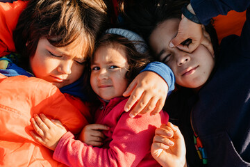 Siblings sleeping together outdoors