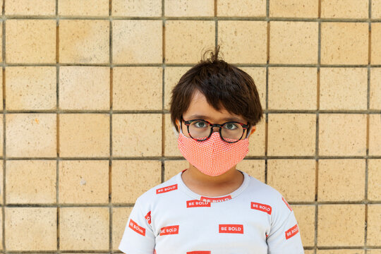 Boy wearing red mask in front of wall