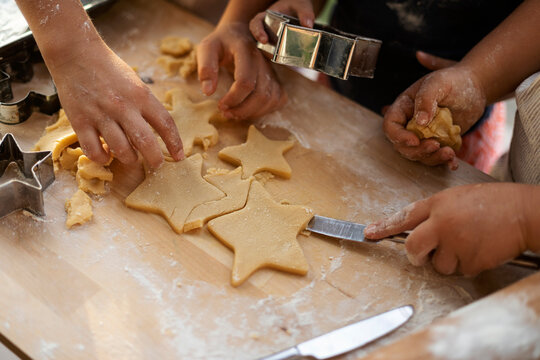 Crop view of children cutting out star shaped cookies