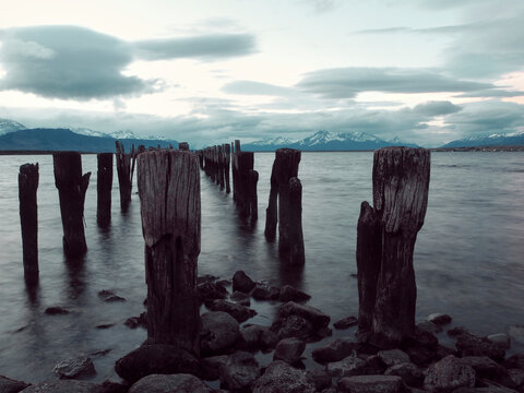 Wooden posts on sea against sky, Puerto Natales, Chile