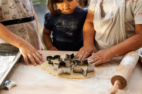 Crop view of children cutting out star shaped cookies
