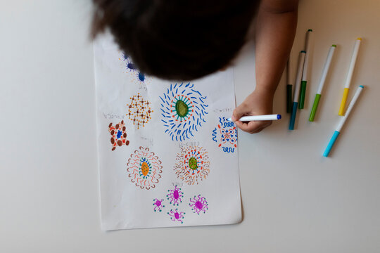 Crop view of little boy drawing flowers