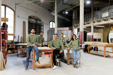 Male and female colleagues at furniture workshop