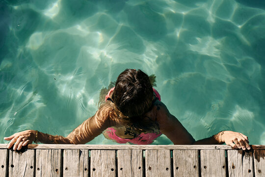 Woman enjoying swimming in pool on sunny day