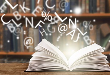 Old book with flying letters and magic light in library. Knowledge, history, memory and information.