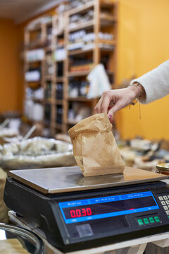 Woman weighting organic food at store