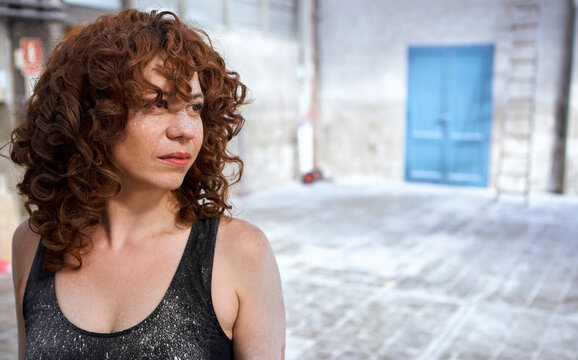 Redhead woman with white dust stains on face looking away