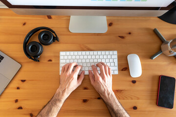Hands of man, working from home, view from above of desk with mobile devices an coffee maker