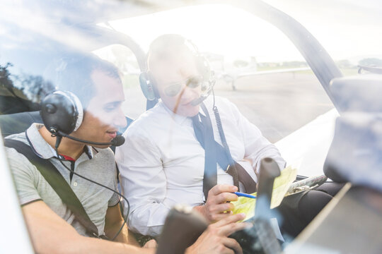 Plot and copilot sitting in sports plane, going through check list