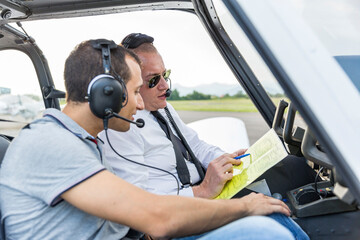 Plot and copilot sitting in sports plane, going through check list