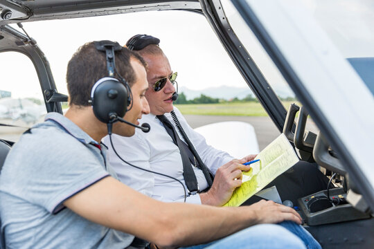 Plot and copilot sitting in sports plane, going through check list