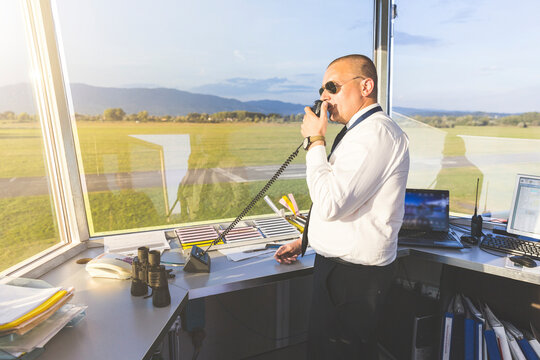 Pilot standing in control tower, talking on the radio