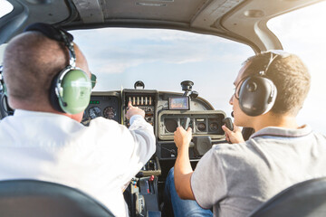 Pilot and copilot navigating sports plane, rear view