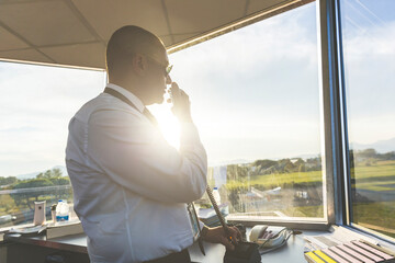 Pilot standing in control tower, talking on the radio