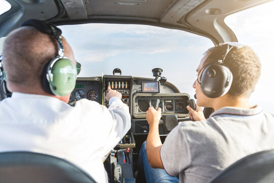 Pilot and copilot navigating sports plane, rear view