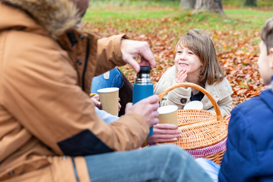Daughter smiling while sitting with family in forest