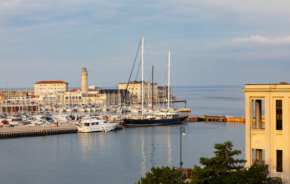 Italy, Friuli Venezia Giulia, Trieste, Boats moored in San Giusto Sea Center marina with&Ocirc;&oslash;&Omega;La Lanterna lighthouse in background
