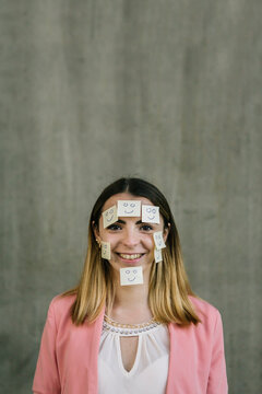 Portrait of smiling woman wearing adhesive notes on face