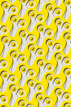 Pattern of rows of school scissors against yellow background