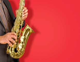 Obraz premium Beautiful golden saxophone on red background,