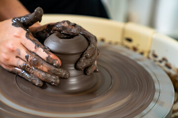  Asian woman sculptor artist hands sculpture clay on pottery wheel at ceramic studio. Female craftsman molding raw clay create pottery shapes at workshop. Small business handicraft product concept.