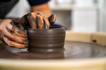  Asian woman sculptor artist hands sculpture clay on pottery wheel at ceramic studio. Female craftsman molding raw clay create pottery shapes at workshop. Small business handicraft product concept.