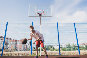a young male basketball player doing dribble drills on the court outdoors