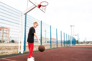 Fototapeta na wymiar male kid playing basketball outdoors