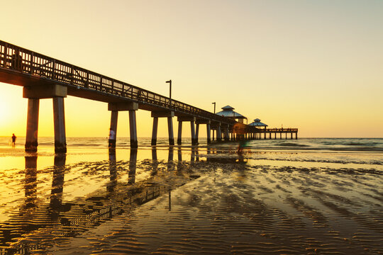 USA, California, Wet beach in front of pier at sunset