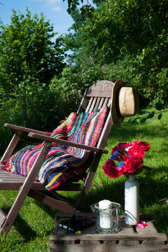 Cushion made of patchwork rug on deckchair in the garden