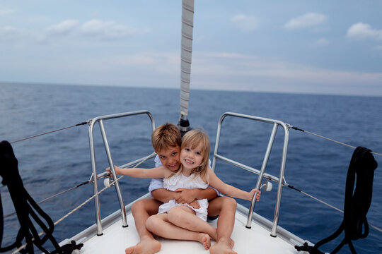 Siblings sitting on boat deck