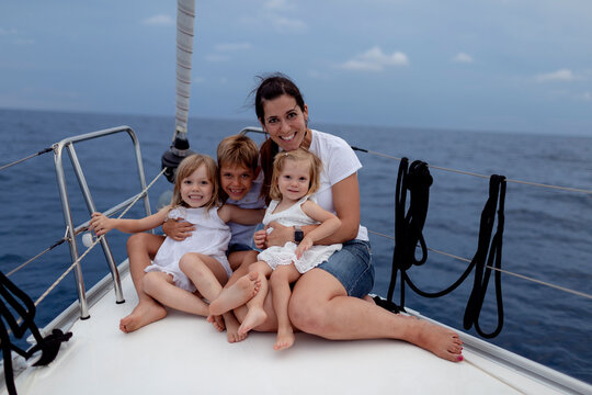 Mother and her children sitting on boat deck during sailing trip