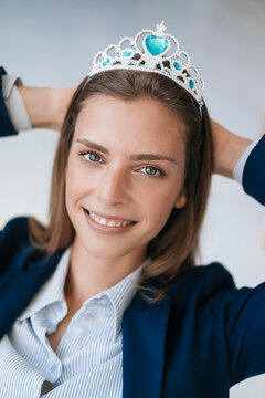 Ambitious young woman wearing crown as an award for her achievments