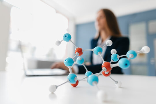 Female scientist studying molecule model - Powered by Adobe