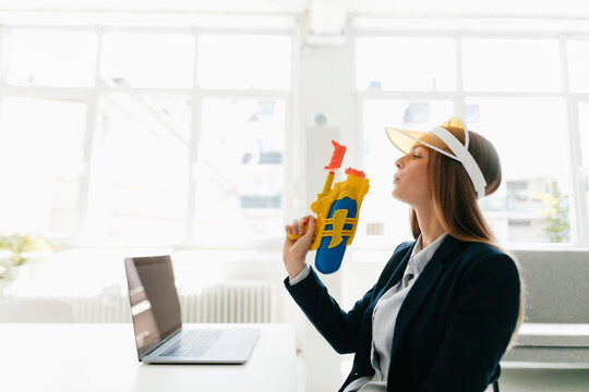 Young businesswoman, holding water gun