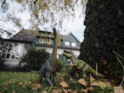 Dinosaur figurines in garden in autumn