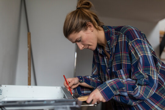 Young woman assembling kitchen