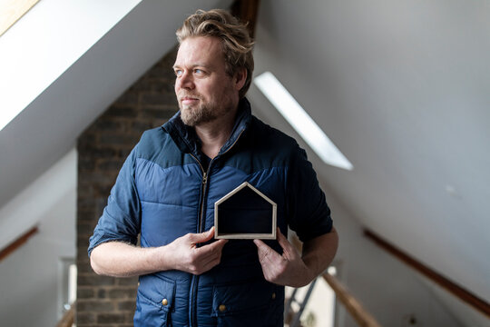 Architect holding wooden house model