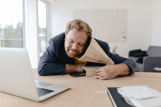 Businessman in office listening to music with a wooden gramophone