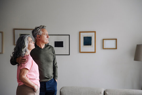 Senior couple standing in living room at home