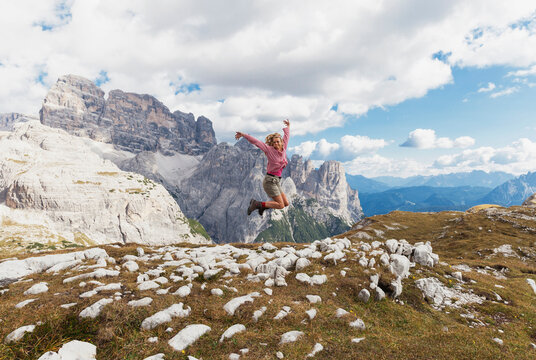 Female hiker jumping, Tre Cime di Lavaredo Area, Nature Park Tre Cime, Unesco World Heritage Natural Site, Sexten Dolomites, Italy