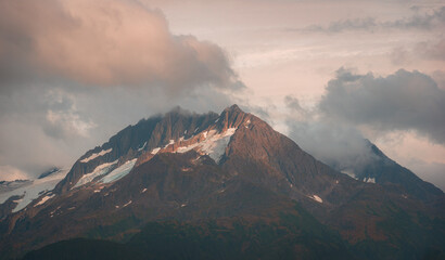 View of mountain peak surrounded by clouds in Alaska, USA.