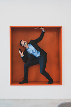Mature businessman with cell phone caught in a niche