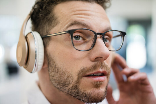 Portrait of businessman listening to music with headphones