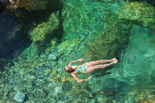 Woman swimming in refreshing Verszasca river