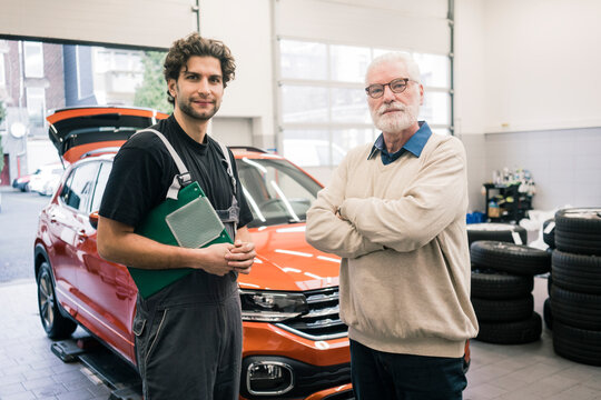 Portrait of car mechanic and client in workshop