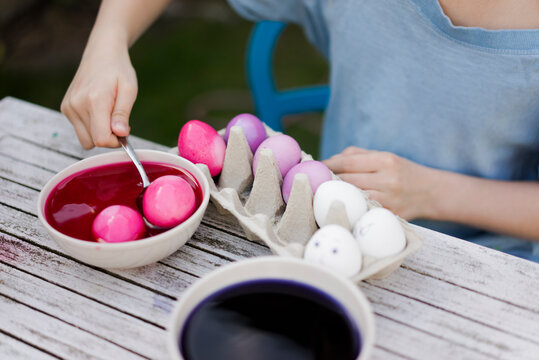Close-up of girl dyeing Easter eggs in garden