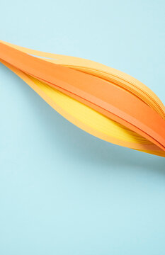 Close-up of yellow quilling papers on blue background