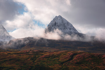 View of mountain peak surrounded by clouds in Alaska, USA.