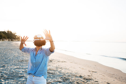 Thailand, Rayong, woman using Virtual Reality Glasses on the beach